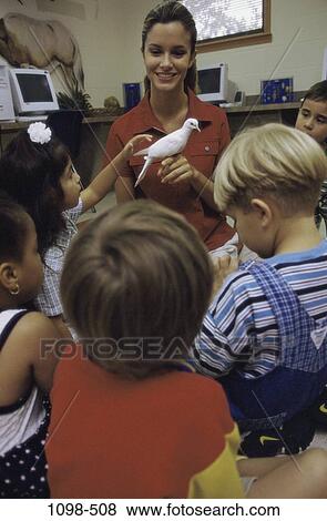 Stock Photo - multiethnic, people, smiling, teacher, bird, zoo, holding. Fotosearch