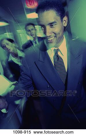 Stock Photography - multiethnic, walking, rush, business, chaotic, smile, hurry. Fotosearch