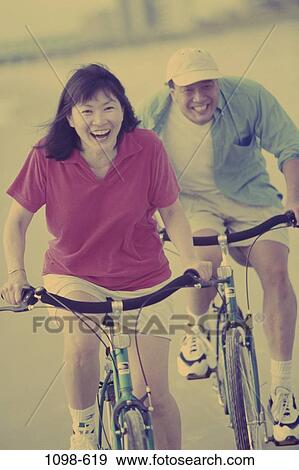 Stock Photo - people, Asian, couple, excitement, racing, laughing, riding. Fotosearch