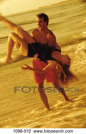 people, couple, Hispanic, beach, laughing, swinging, playful View Large Photo Image Stock Image - people, couple, Hispanic, beach, laughing, swinging, playful. Fotosearch