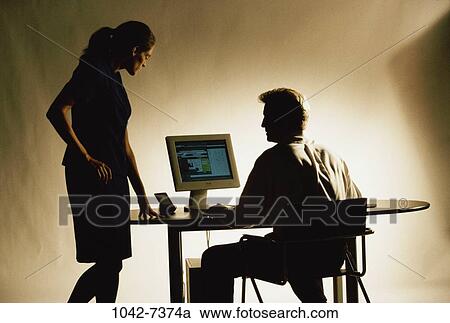Stock Image - people, desk, coworkers, discussion, computer, consulting, silhouette. Fotosearch
