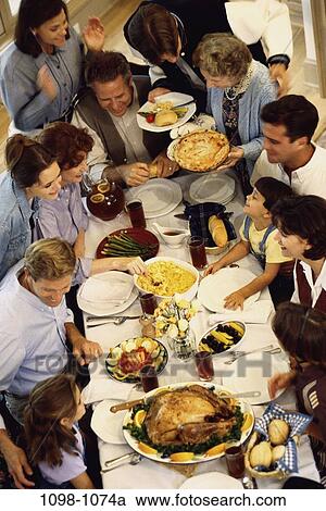 Stock Image - people, eating, party, table, sitting, standing, dinner. Fotosearch