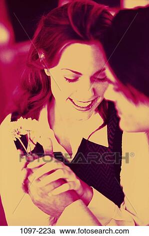 Stock Image - people, hands, smiling, couple, holding, flower, lifestyles. Fotosearch
