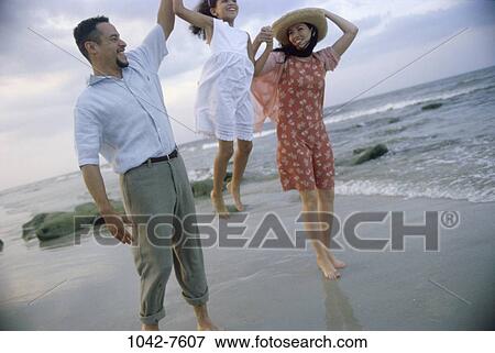 Stock Photo - people, hat, Hispanic, beach, playful, Middle-aged, joyous. Fotosearch