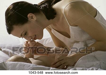 Stock Photo - people, mother, baby, bed, family, affection. Fotosearch
