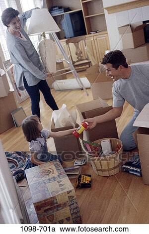 Stock Image - people, moving, lifestyles, family, new home, boxes, packing. Fotosearch