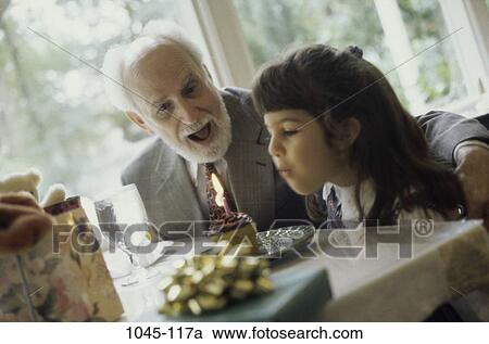 Stock Image - people, party, excitement, excited, birthday, blowing. Fotosearch
