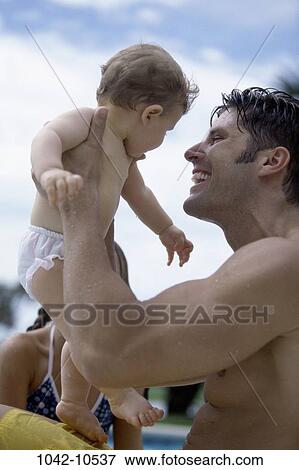 Stock Photo - people, pool, smiling, baby, holding, outdoors, poolside. Fotosearch