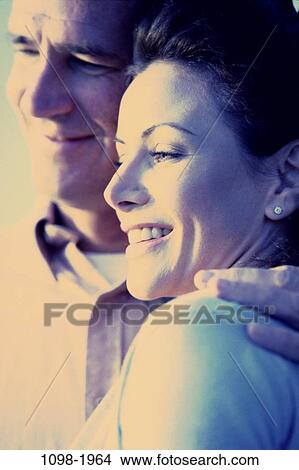 people, smiling, couple, blue, outdoors, Middle-aged, hugging View Large Photo Image Picture - people, smiling, couple, blue, outdoors, Middle-aged, hugging. Fotosearch