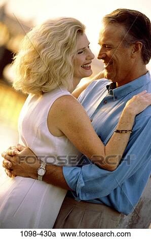 Stock Image - people, smiling, couple, happy, outdoors, Middle-aged, hugging. Fotosearch