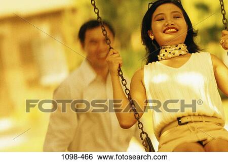 people, smiling, happy, swinging, playful, soft, couples outdoors View Large Photo Image Stock Photograph - people, smiling, happy, swinging, playful, soft, couples outdoors. Fotosearch