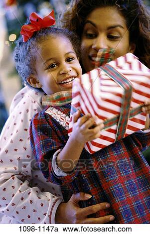 people, smiling, mother, wrapped, Christmas, holding, curious View Large Photo Image Stock Image - people, smiling, mother, wrapped, Christmas, holding, curious. Fotosearch