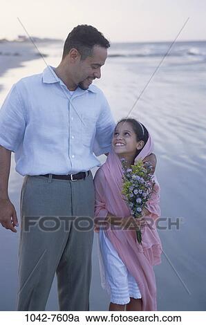 Stock Image - people, walking, Hispanic, beach, flowers, tranquility, nurturing. Fotosearch