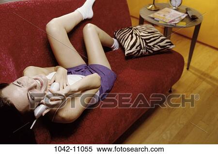 Stock Photography - people, woman, smiling, telephone, talking, phone, couch. Fotosearch