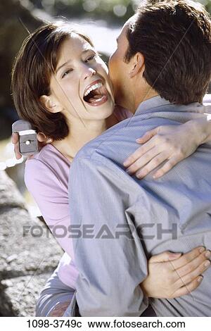 Stock Image - couple, excitement, outdoors, romantic, hugging, joyous, commitment. Fotosearch
