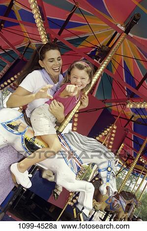 Stock Image - excitement, mother, riding, pointing, outdoors, amusement, point. Fotosearch