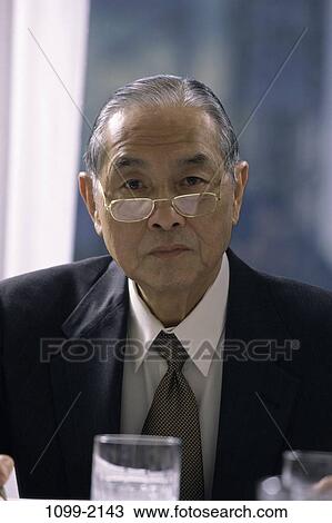 Stock Image - eyeglasses, serious, business, senior, Asian. Fotosearch