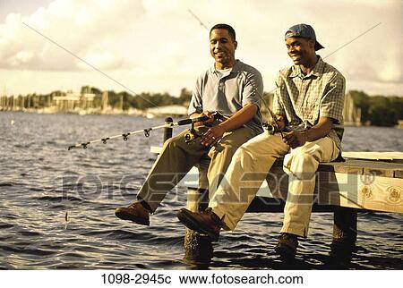 Stock Image - fish, men, relaxation, sitting, laughing, outdoors. Fotosearch