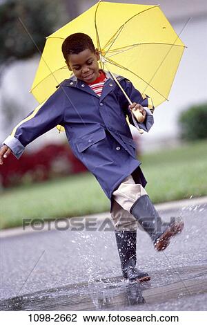 Stock Image - grass, people, water, playing, umbrella, road, rain. Fotosearch