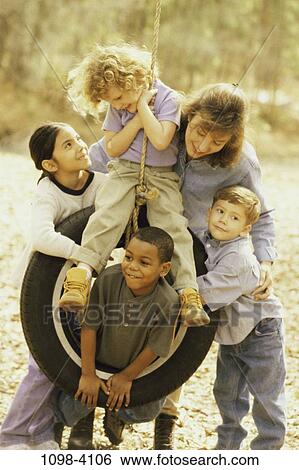 Stock Photograph - group, multiethnic, people, yellow, friendship, swing, outdoors. Fotosearch