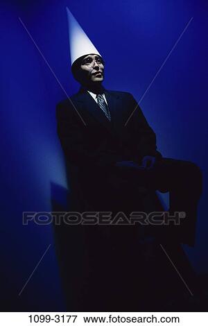 Stock Photo - hat, business, Middle-aged, humor, businessman, dunce cap. Fotosearch