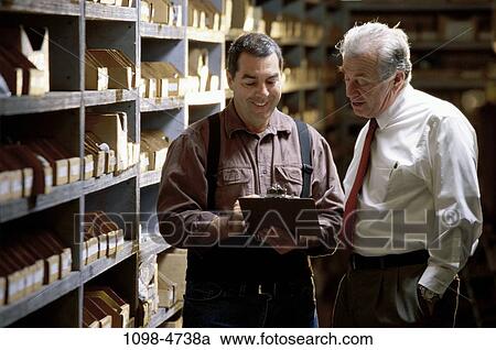 Stock Image - men, talking, boss, senior, warehouse, inventory, Caucasian. Fotosearch