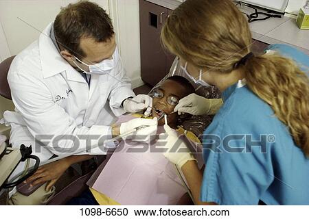 Stock Image - multiethnic, patient, dentist, doctor, equipment, tools, health. Fotosearch