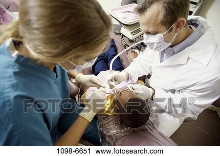 Stock Image - multiethnic, patient, dentist, doctor, equipment, tools, health. Fotosearch
