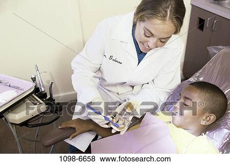 Stock Photo - multiethnic, smiling, patient, dentist, doctor, health, explaining. Fotosearch