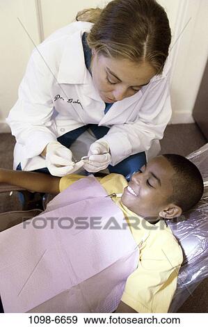 Stock Photo - multiethnic, smiling, patient, dentist, doctor, health, explaining. Fotosearch