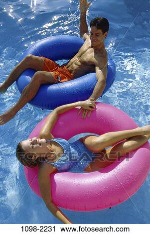 Stock Image - overhead, people, floating, water, pool, couple, outdoors. Fotosearch