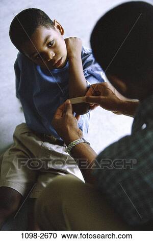 Stock Image - people, bandage, injury, nurturing, father, caring. Fotosearch