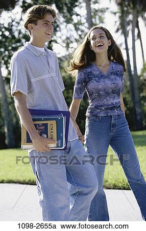 Stock Image - people, couple, books, school, laughing, teens, brunette. Fotosearch