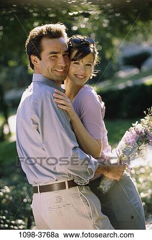 people, couple, flowers, outdoors, romantic, hugging, unity View Large Photo Image Stock Image - people, couple, flowers, outdoors, romantic, hugging, unity. Fotosearch