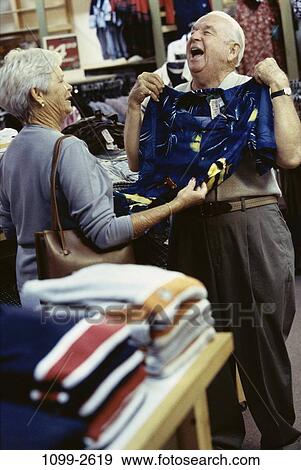 Stock Photo - people, couple, shirt, senior, laughing, shopping, clothes. Fotosearch