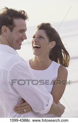 people, couple, windy, beach, laughing, hugging, breeze View Large Photo Image Stock Image - people, couple, windy, beach, laughing, hugging, breeze. Fotosearch