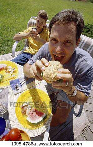 people, eating, hamburger, picnic, outdoors, family View Large Photo Image Stock Image - people, eating, hamburger, picnic, outdoors, family. Fotosearch