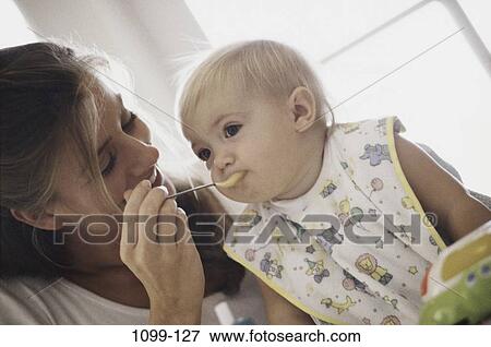 Stock Photo - people, eating, mother, baby, spoon, nurturing. Fotosearch