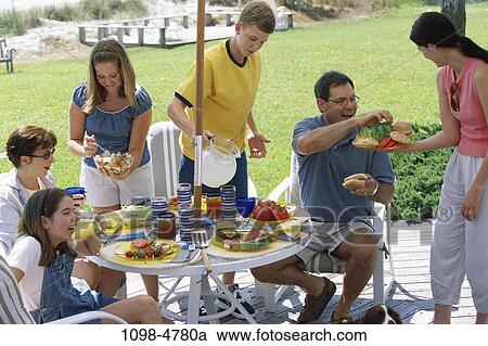 people, eating, sitting, picnic, pouring, outdoors, family View Large Photo Image Stock Image - people, eating, sitting, picnic, pouring, outdoors, family. Fotosearch