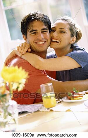 Stock Image - people, eating, smiling, couple, Hispanic, orange juice, breakfast. Fotosearch