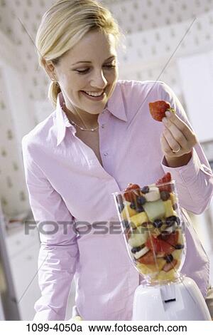 Stock Image - people, eating, woman, healthy, fruit, holding, strawberry. Fotosearch