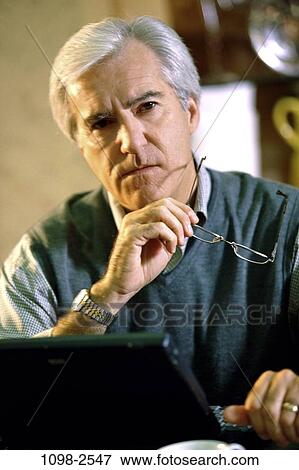 Stock Photo - people, home, eyeglasses, pensive, senior, computer. Fotosearch