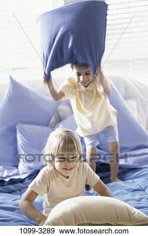 people, home, smiling, playing, pillow, bed, playful View Large Photo Image Stock Photo - people, home, smiling, playing, pillow, bed, playful. Fotosearch