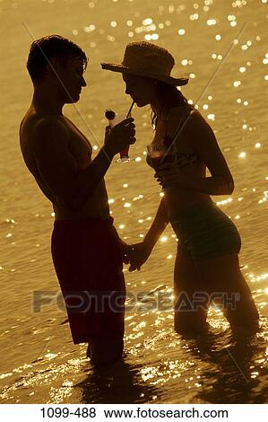 Stock Photo - people, reflection, water, hat, couple, ocean, Hispanic. Fotosearch