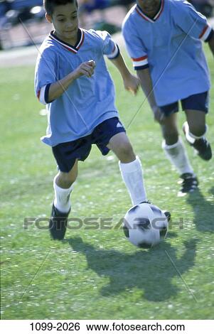 Stock Photograph - people, running, ball, teamwork, competition, boys, determination. Fotosearch