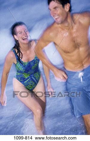 Picture - people, running, couple, beach, laughing, Middle-aged, brunette. Fotosearch