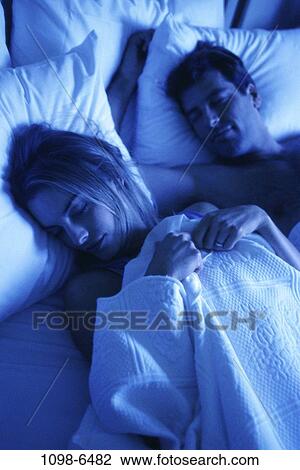 Stock Image - people, sleeping, couple, bed, bedroom, pillows, asleep. Fotosearch
