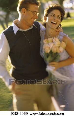 Stock Photo - people, smiling, couple, eyeglasses, flowers, outdoors, park. Fotosearch