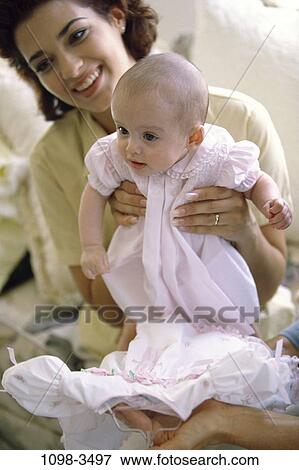 people, smiling, mother, baby, couch, holding, dress View Large Photo Image Stock Photo - people, smiling, mother, baby, couch, holding, dress. Fotosearch