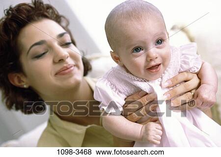 Stock Photo - people, smiling, mother, baby, pleased, holding. Fotosearch